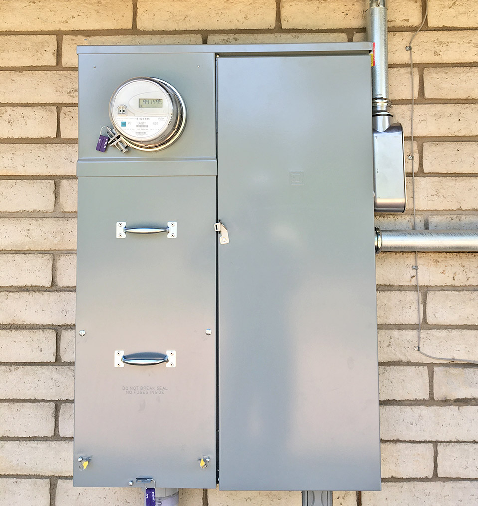 A commercial electric panel mounted to a block wall on the outside of a building in Flagstaff AZ